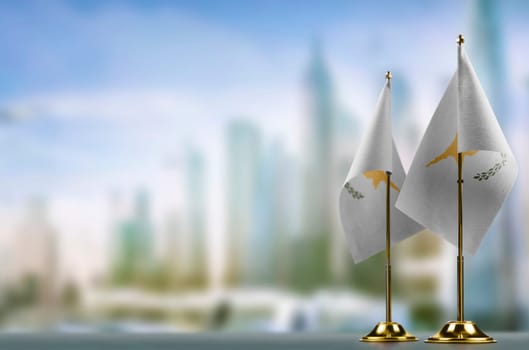 Small flags of the Cyprus on an abstract blurry background.