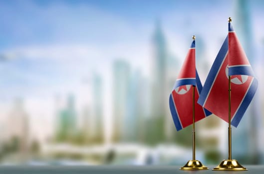 Small flags of the North Korea on an abstract blurry background.