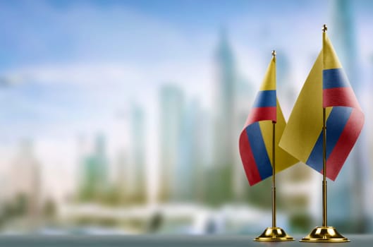 Small flags of the Colombia on an abstract blurry background.
