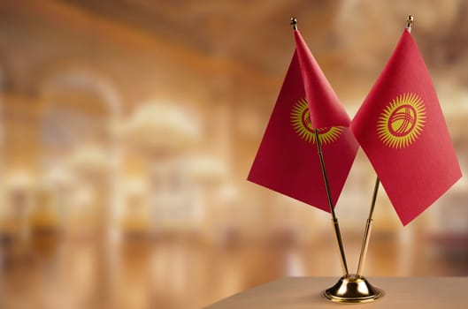 Small flags of the Kirghizia on an abstract blurry background.
