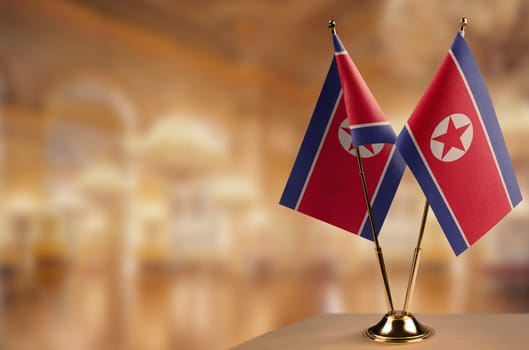 Small flags of the North Korea on an abstract blurry background.