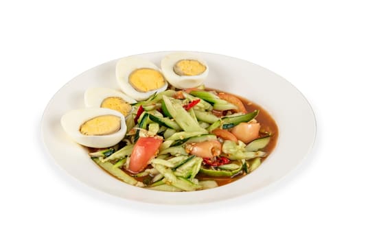 spicy cucumber  salad served with boiled eggs,  thai spicy food on dish over white background