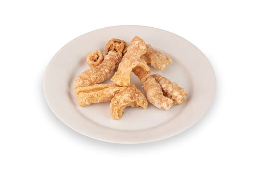 pork scratching or pork crackling on dish on dish over white background