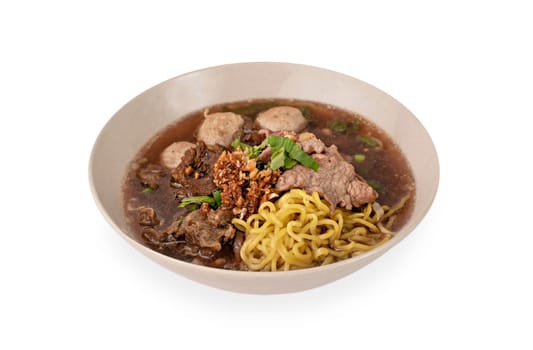 Asian yellow noodles with pork and vegetables in bowl over white background