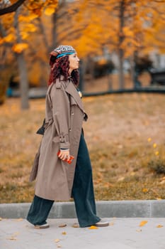 A woman walks outdoors in autumn, enjoys the autumn weather