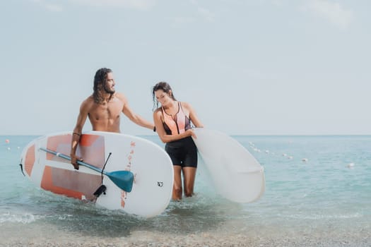 Woman man sea sup. Close up portrait of beautiful young caucasian woman with black hair and freckles looking at camera and smiling. Cute woman portrait in a pink bikini posing on sup board in the sea