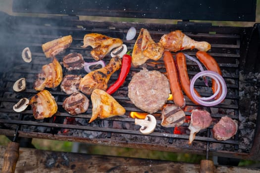 Assorted delicious grilled meat with vegetables over the coals on a barbecue. High quality photo