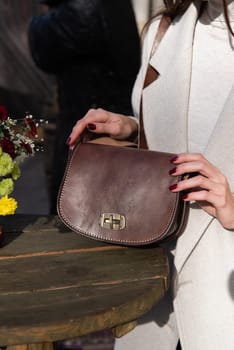 photo of a womans hyands with a brown leather handbag with retro look.