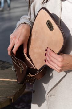 photo of a womans hyands with a brown leather handbag with retro look.