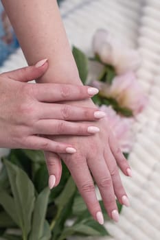 girl's hands with a beautiful pink manicure design, pastel color, gently, flowers in spring. High quality photo