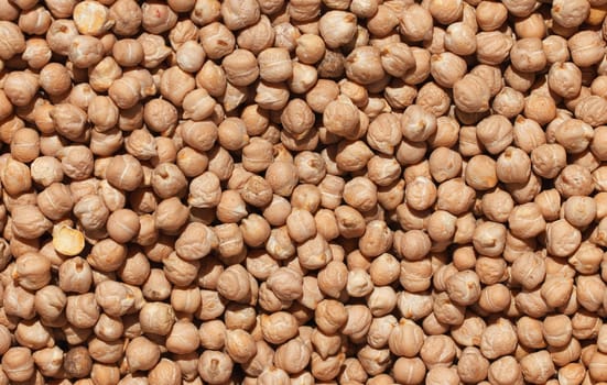 Raw chickpea beans. Top view on chickpea seeds. Food background from a texture of raw chickpeas close-up, top view. Uncooked chickpea