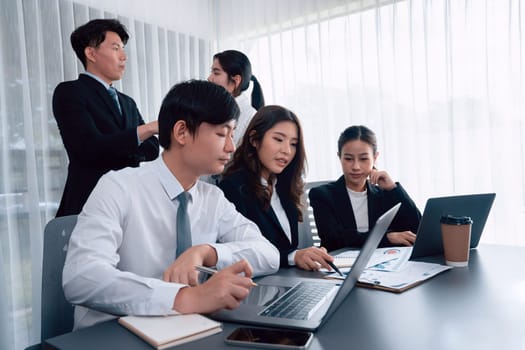 Harmony in office concept as business people analyzing dashboard paper together in workplace. Young colleagues give ideas at manager desk for discussion or strategy planning about project.