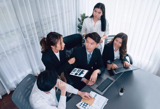 Harmony in office concept as business people analyzing dashboard paper together in workplace. Young colleagues give ideas at manager desk for discussion or strategy planning about project.