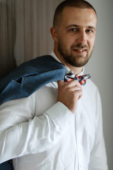 portrait of smiling groom with beard in blue color suit