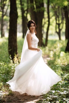 portrait of an elegant bride girl on a path in a deciduous forest