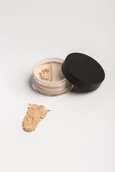 Mineral makeup powder isolated on white background. Light beige foundation powder. Skin tone face cosmetic product sample concept
