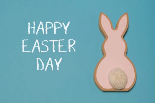Easter composition with a wooden rabbit on a blue background. Banner. copy space. Template Easter day