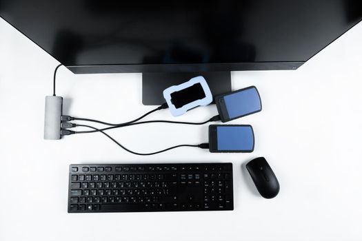 Multiple external hard drives connected to a monoblock on a white background.Computer with hard drive.