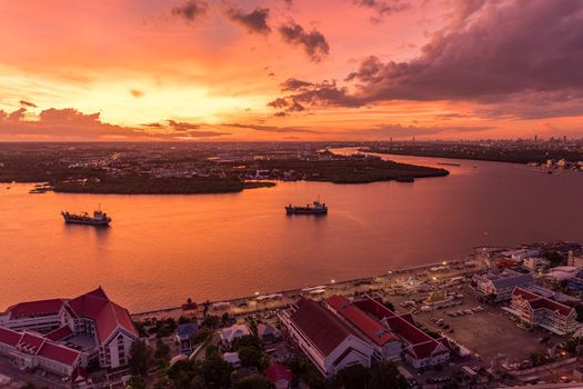 Bird's eye view of Samut Prakan, Thailand. Sunset over the Chao Phraya River, orange sky.