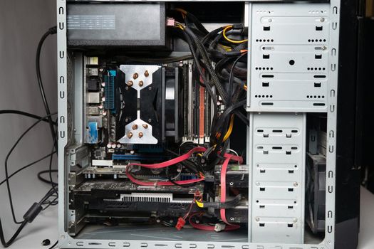 The system unit of the computer is disassembled without a cover.Lots of old computer parts. computer from the inside.