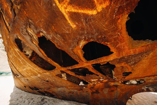 Rusted with holes, the ship is on the sea shore.Rusty ship in the Bay of Navagio on the island of Zakynthos.
