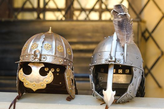 Two knight's helmets are lying on the surface.Medieval concept.
