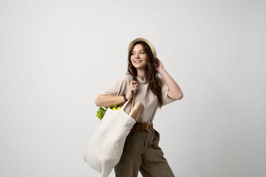 Zero waste concept. Woman holding reusable cotton shopping bag with groceries. Plastic free. Eco friendly concept. Sustainable lifestyle