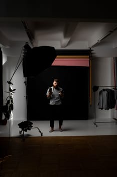 Professional handsome bearded male photographer with bunch of vintage photo cameras in photo studio