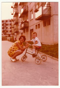 THE CZECHOSLOVAK SOCIALIST REPUBLIC, CIRCA 1974: Vintage photo shows mother with her son on tricycle, circa 1974.