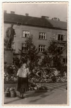 HODONIN, THE CZECHOSLOVAK REPUBLIC, CIRCA 1940s: Vintage photo shows rural woman in front of sculpture (Tomas Garrigue Masaryk), circa 1940s.