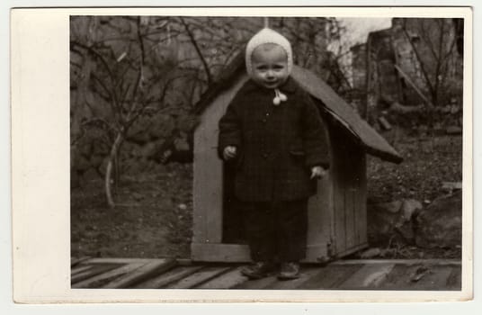 THE CZECHOSLOVAK REPUBLIC, CIRCA 1942: Vintage photo shows a small girl and kannel (doghouse), circa 1942.