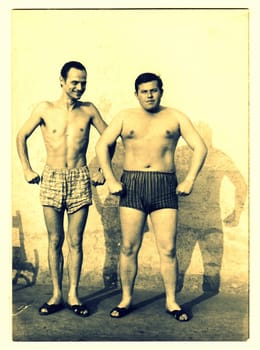 THE CZECHOSLOVAK SOCIALIST REPUBLIC, CIRCA 1965: A vintage photo shows men and their muscular bodies. Photo has sepia effect.