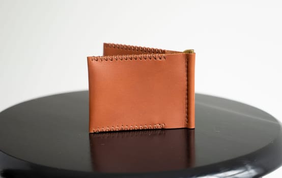 Orange men's money clip handmade leather wallet with a two pockets on a black table