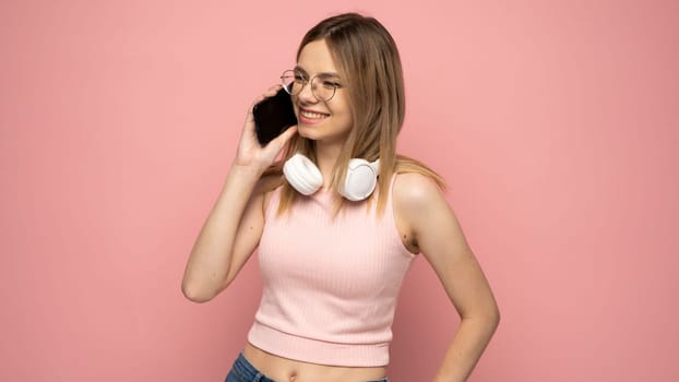 Young blond woman over isolated pink background using mobile phone