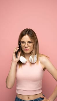 Portrait of a cheerful woman talking on mobile phone and looking at camera isolated over yellow background