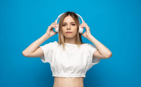Portrait of a girl listening music with wireless headphones from a smartphone. Girl uses wireless earphones and dancing