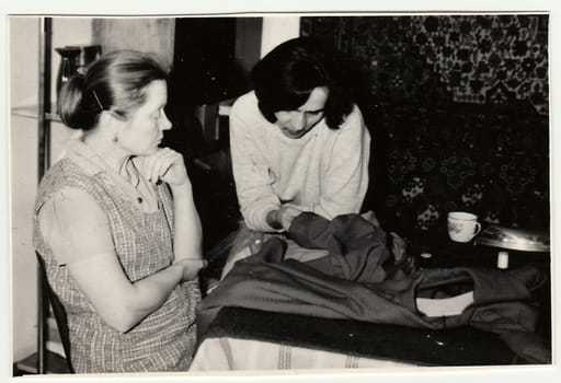 USSR - CIRCA 1970s: Vintage photo shows women preparing to sew a dress.