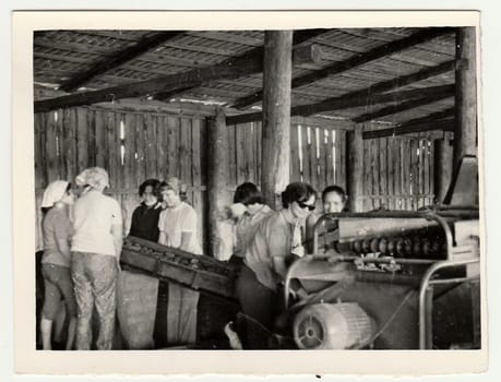 USSR - CIRCA 1980s: Vintage photo shows women work on a farm. They work at the sorting machine (sort potatoes).
