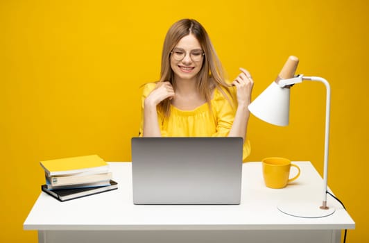 Studio portrait of young successful secretary employee business woman wear yellow t-t-shirt sit work at white office desk with laptop browsing internet online