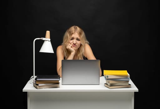 Frustrated, sad, stressed or depressed woman feeling tired while working with a laptop on a black background