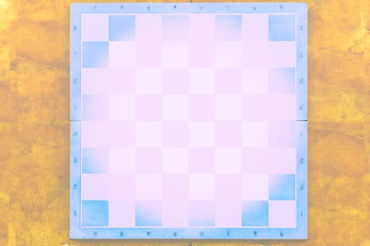 a square board divided into sixty-four alternating dark and light squares, used for playing chess or checkers.