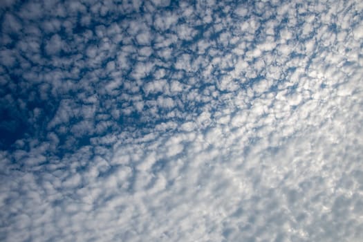 Peaceful blue sky overhead, texture with white cirrus clouds, natural background. High quality photo