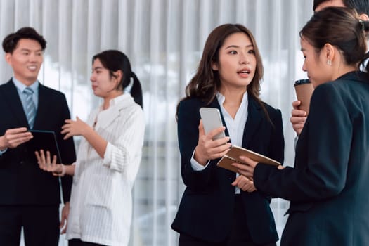 Mentor, manager with coffee advice younger colleagues in workplace. Businesspeople discussing or planning financial project strategy, talking together for harmony and strong teamwork in office concept