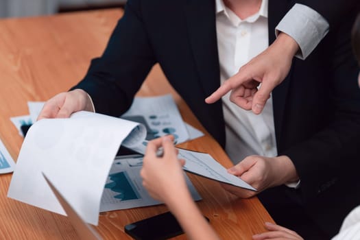 Harmony in office concept as business people analyzing dashboard paper together in workplace. Young colleagues give ideas at manager desk for discussion or strategy planning about project.