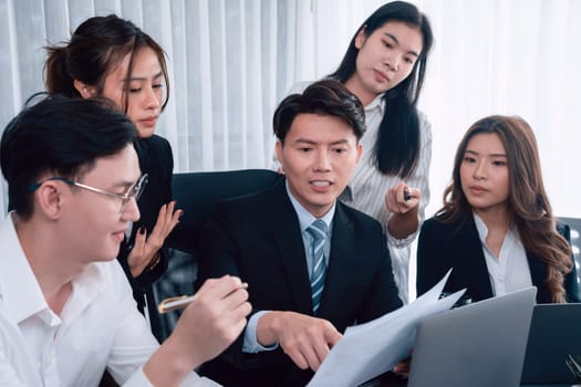 Harmony in office concept as business people analyzing dashboard paper together in workplace. Young colleagues give ideas at manager desk for discussion or strategy planning about project.