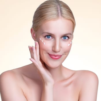 Personable beautiful perfect clean skin soft makeup woman finger applying moisturizer cream on her face under contour eye for anti aging wrinkle. Facial skin rejuvenation in isolated background.