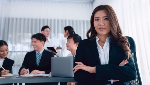 Focus portrait of female manger, businesswoman in the harmony meeting room with blurred of colleagues working together, analyzing financial paper report and dashboard data in background.