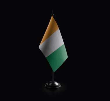 Small national flag of the Cote dIvoire on a black background.
