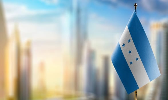 Small flags of the Honduras on an abstract blurry background.