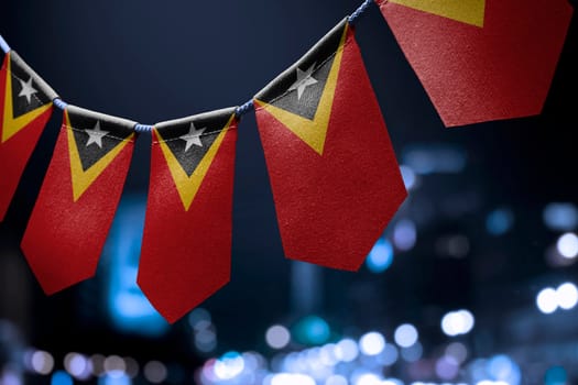 A garland of East Timor national flags on an abstract blurred background.